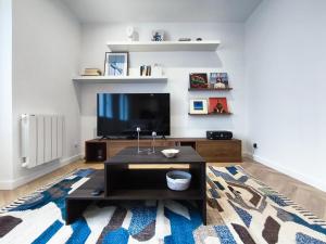 a living room with a coffee table and a flat screen tv at L'Azur - Appartement spacieux - Arrivée Autonome in Brest