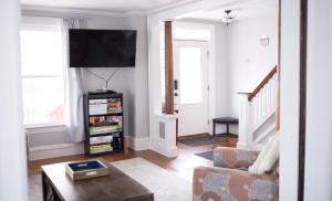 a living room with a couch and a flat screen tv at Cityside Escape Spacious with Game Room & Fire Pit in Geneva +30 photos