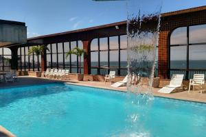a swimming pool with a water fountain at Sensacional Flat pé na areia na Praia da Costa in Vila Velha