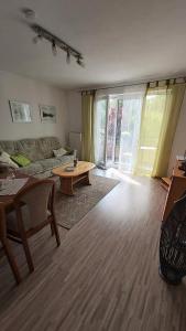 ein Wohnzimmer mit Sofa und Tisch in der Unterkunft Ferienhaus Bohlingen - Haus 26 in Singen