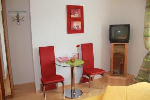 una camera con tavolo, due sedie e una TV di Haus Regina a Maria Taferl