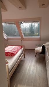 ein Schlafzimmer mit einem Bett und einem großen Fenster in der Unterkunft Ferienhaus Bohlingen - Haus 26 in Singen
