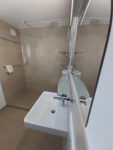 ein weißes Badezimmer mit Waschbecken und Dusche in der Unterkunft Ferienhaus Bohlingen - Haus 26 in Singen + 15 Fotos