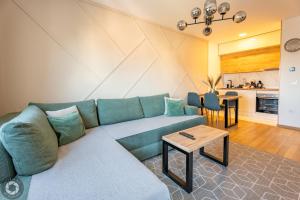 ズラティボールにあるApartment 5A bed & breakfast Zlatiborの青いソファとテーブルのあるリビングルーム