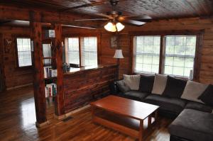 un soggiorno con un divano e un ventilatore a soffitto di Martin Springs Cabin a South Pittsburg
