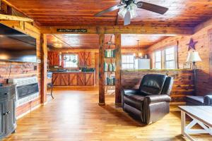 un soggiorno con un ventilatore a soffitto e una poltrona in pelle di Martin Springs Cabin a South Pittsburg