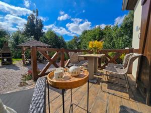 a patio with a table and chairs on a deck at Apartamenty Komarno 46 Jacuzzi&Sauna in Komarno