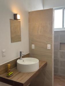 a bathroom with a white sink and a shower at Hotel Mochomos Huajuapan in Huajuapan de León
