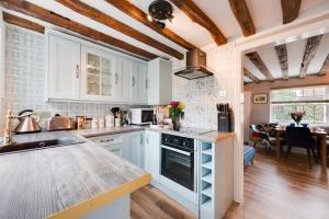 eine Küche mit weißen Schränken und einer Arbeitsplatte in der Unterkunft Puddingmoor Cottage in Beccles