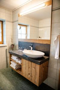 une salle de bain avec un lavabo et un miroir dans l'établissement Kröll-Hube, à Sankt Johann im Saggautal