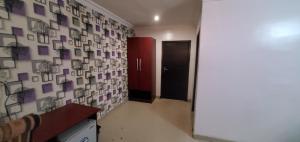Un pasillo con una puerta roja y una pared con fotografías. en Skyfield Hotel & Suits, en Lekki