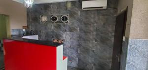 Una habitación con un mostrador rojo y una pared de piedra. en Skyfield Hotel & Suits, en Lekki