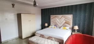 Un dormitorio con una cama y una silla roja. en Skyfield Hotel & Suits, en Lekki