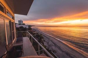 a view of the beach at sunset from a balcony at El Penthouse Suite in La Chumicosa