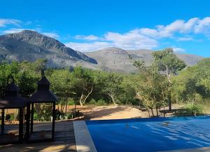 a swimming pool with mountains in the background at Cabana Zé da Lapinha - Passarela in Santana do Riacho