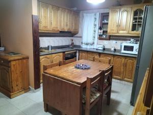 a kitchen with wooden cabinets and a wooden table at El Pajar casa campestre in El Pinar del Hierro