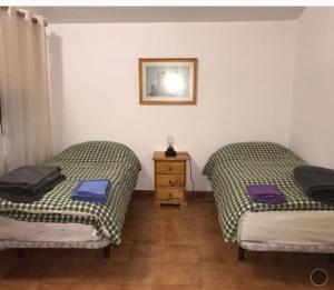 two twin beds in a room with a wooden floor at El Pajar casa campestre in El Pinar del Hierro