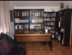 a library with a desk and book shelves filled with books at El Pajar casa campestre in El Pinar del Hierro