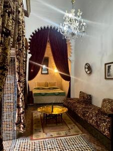 a living room with a chandelier and a table at Riad Dar Dahlia Tetouan in Tétouan
