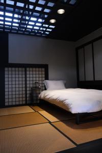 a bedroom with a bed with white sheets and a window at A rental house where you can stay in a residential - Vacation STAY 18763 in Honchō