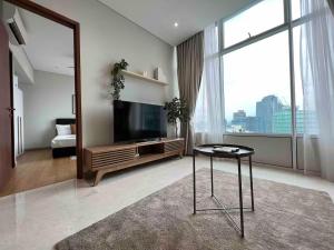 a living room with a tv and a table and a mirror at Luxury Suites Twin Tower in Kuala Lumpur
