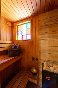 een kamer met een sauna met een raam en een bad bij Atpūtas komplekss Usmas Meķi in Renda