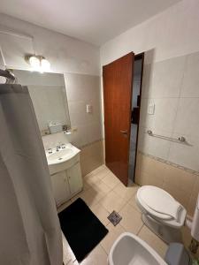une salle de bain avec un lavabo, des toilettes et un miroir dans l'établissement La rioja Flat, à Paraná