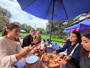 a group of people sitting at a table eating pizza at Blue Moon Hostel in Antigua Guatemala