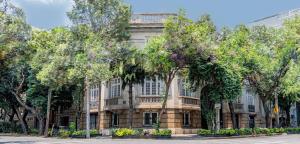 an old building with trees in front of it at El Cortés, Member of Relais & Châteaux in Mexico City