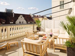 eine Terrasse mit Stühlen und einem Tisch auf einem Balkon in der Unterkunft Mandarin Oriental, Munich in München
