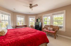 a bedroom with a red bed and chairs and windows at Show Boat in Kitty Hawk +122 photos