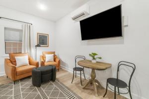Una sala de estar con televisión, mesa y sillas. en Village of SoWal B257, en Rosemary Beach
