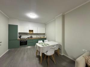 a kitchen with a table and chairs in a room at Brand new condo for rent in Tirana