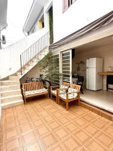 a patio with two wooden benches and a staircase at Aconchego em congonhas- CGH in Sao Paulo