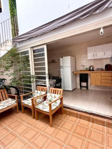 a patio with two chairs and a table and a kitchen at Aconchego em congonhas- CGH in Sao Paulo