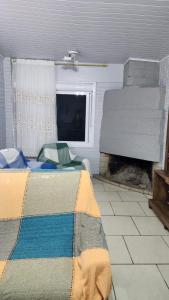 Un dormitorio con chimenea y una cama con manta. en Casa de Férias, en Capão da Canoa