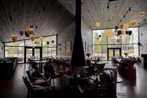a restaurant with tables and chairs and large windows at Arctic TreeHouse Hotel in Rovaniemi