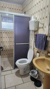 Un baño con inodoro, ducha y lavabo. en Casa de Férias, en Capão da Canoa
