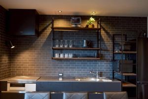 a kitchen with a sink and a brick wall at Kamogawa Sea Sauna Villa Kaito - Vacation STAY 08186v in Kamogawa +16 photos