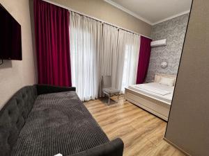 a bedroom with a bed and red curtains at Siena Hotel in Odesa