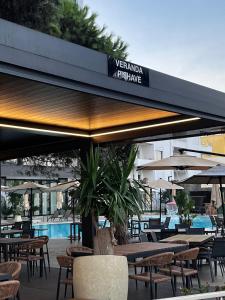 um restaurante com mesas e guarda-sóis e uma piscina em Three above Sea apartment em Golem