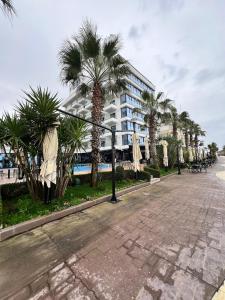 uma rua com palmeiras em frente a um edifício em Three above Sea apartment em Golem mais 54 fotografias