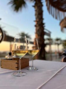 dois copos de vinho branco sentados numa mesa em Three above Sea apartment em Golem