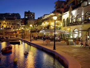 a city at night with a river and buildings at Sea-mist luxury escape in St. Julianʼs