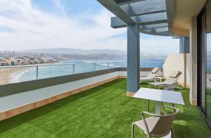 een balkon met stoelen en uitzicht op de oceaan bij NH Imperial Playa in Las Palmas de Gran Canaria