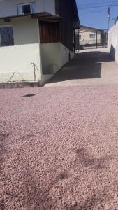 a pile of pink gravel next to a building at Casa de Hóspedes Espaçosa - Auto Check-In - Mafra SC in Mafra