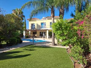 a villa with a swimming pool and palm trees at Latchi coast villa-resort in Lachi
