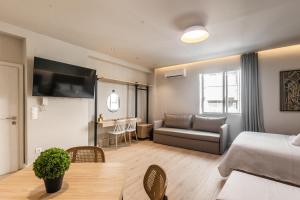 テッサロニキにあるNoima Luxury Suitesのベッドルーム1室、リビングルーム(ベッド1台、ソファ付)