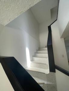 a staircase in a room with white walls and black trim at Habitacion con aire y baño privado in Valledupar