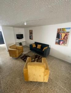 a living room with a couch and a tv at Habitacion con aire y baño privado in Valledupar
